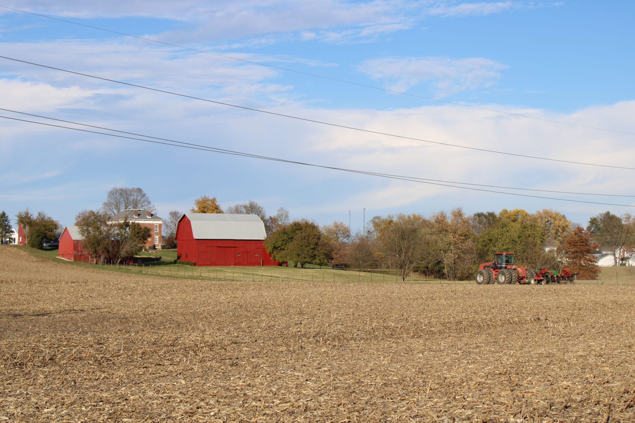 A red barn and farmhouse above a harvested field, the kind of family property in Doddridge County, West Virginia whose mineral estate has passed down through several generations of heirs