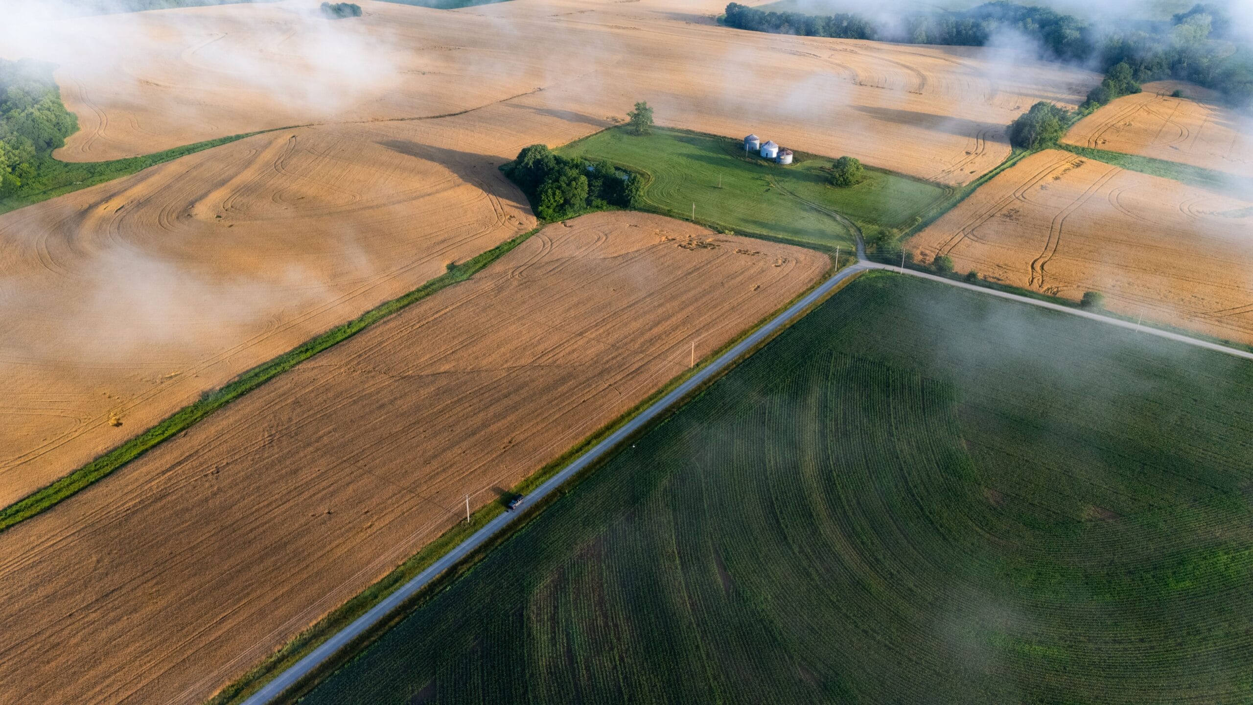 Aerial view of flat farmland divided by a road into distinct rectangular tracts, illustrating how DeSoto Parish, Louisiana mineral acreage is split across separate 640-acre Haynesville drilling units.